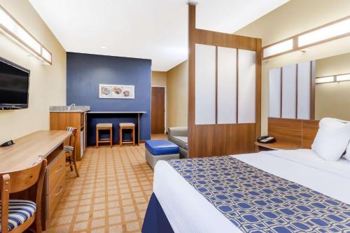 Dickson City迈克泰尔旅馆&套房酒店的配有一张床和一张书桌的酒店客房