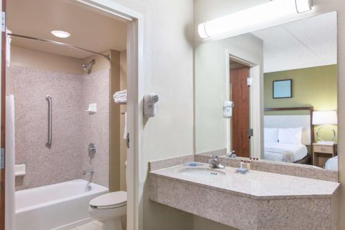 米德韦斯特城中西部城市豪顿套房酒店的一间带水槽、卫生间和镜子的浴室