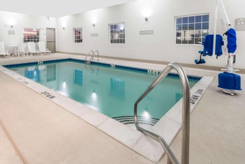 斯威特沃特Microtel Inn & Suites by Wyndham Sweetwater的一座带自动扶梯的游泳池,通往一座建筑