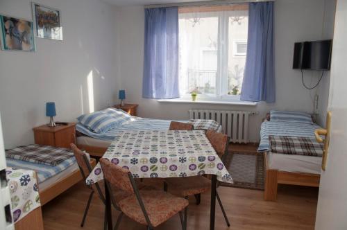 达洛科APARTAMENT i pokoje Aura Dom Wczasowy的小房间设有桌子和两张床
