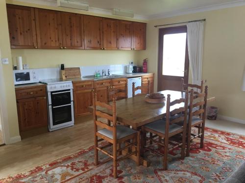 克雷格纽尔Shieling Holidays Mull的厨房配有木桌和木橱柜。