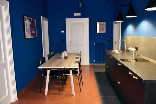 阿尔塔穆拉XVIII Arcano的厨房拥有蓝色的墙壁,配有桌椅