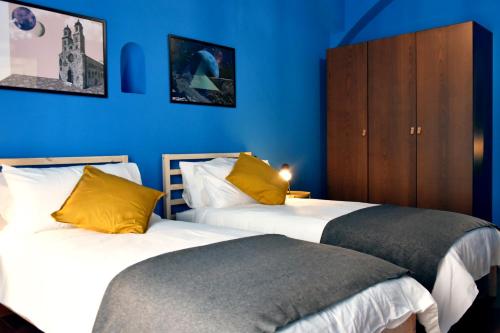 阿尔塔穆拉XVIII Arcano的蓝色墙壁客房的两张床
