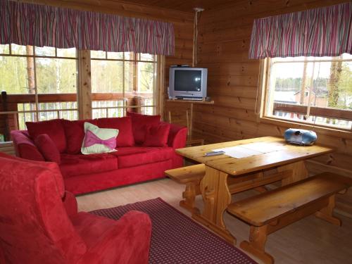 塔库沃里洛马-拉昂塔拉小屋酒店的客厅配有红色的沙发和桌子