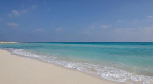 阿莱曼Lazorde Beachfront Experience的一片海水和蓝色的海滩