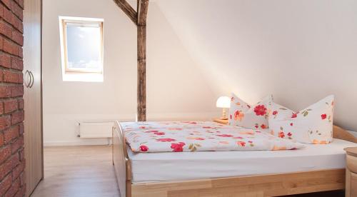 柯尼希施泰因易北Ferienwohnung Liliensteinblick的白色卧室,配有红色鲜花的床