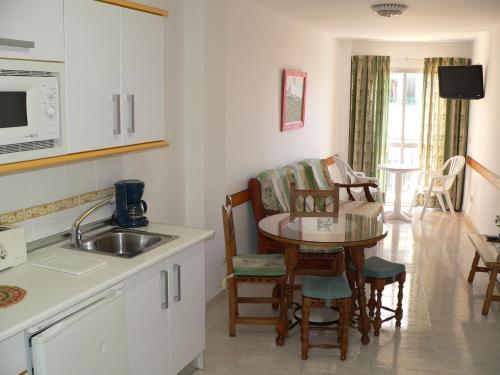 内尔哈卡萨诺瓦公寓酒店的厨房配有水槽和桌椅
