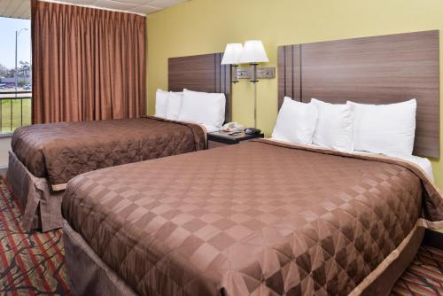 西门罗西门罗美国最有价值旅馆的酒店客房设有两张床和窗户。