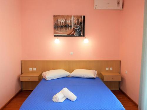 利迈纳里亚Apartment Christos Limenaria的一间卧室配有蓝色的床和2条毛巾