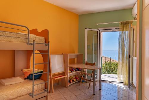 劳德哈塔Ioannis House Sea View的一间带双层床和书桌的卧室以及一个阳台