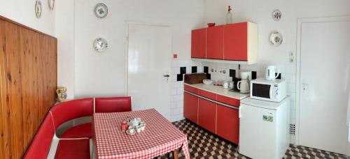 索普隆Julius Vendégház的一间小厨房,配有红色橱柜和红色的桌子及椅子