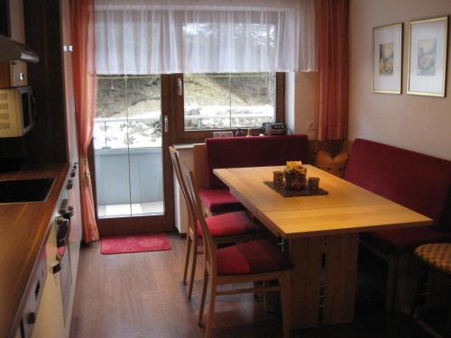 卡普尔Apart Kathrin的厨房配有木桌、椅子、桌子和窗户。