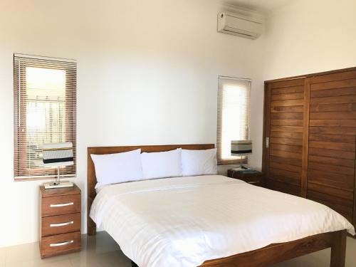 罗威那皮特尔别墅的一间卧室设有一张大床和两个窗户。