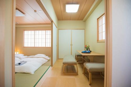 大阪有秋酒店的客房设有两张床、一张桌子和一面镜子。
