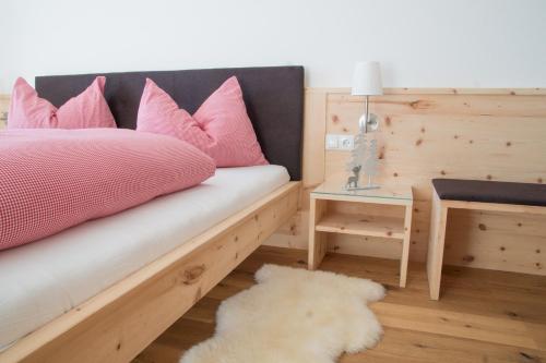 维兰德罗Tschott Hof的一间卧室配有一张带粉红色枕头的床和一张桌子