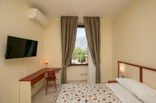 苏尔莫纳B&B Ponte Capograssi的配有一张床、一张书桌和一扇窗户的酒店客房