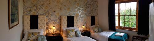 泰姆恩格兰兹玫瑰酒店的一间卧室设有两张床和窗户。