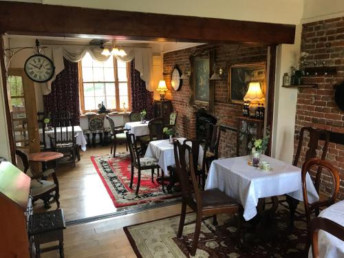 泰姆恩格兰兹玫瑰酒店的一间带桌椅的餐厅以及砖墙