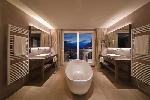 蒂鲁罗Hotel Patrizia的一间带大浴缸和大窗户的浴室