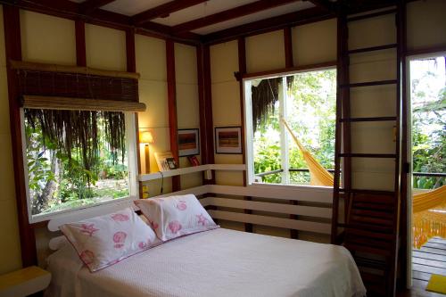 伊尔哈德博伊巴Pousada Vila Sereia的一间卧室设有2扇窗户和一张带白色床单的床