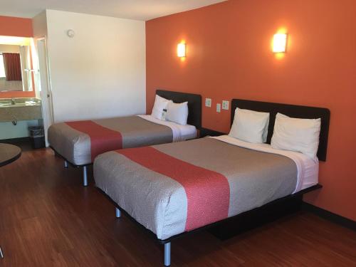 里士满Motel 6-Richmond, VA - Midlothian Turnpike的橙色墙壁的酒店客房内的两张床