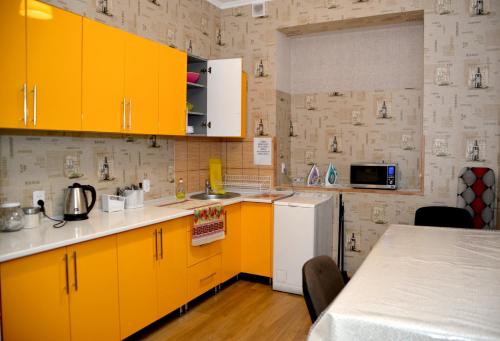 利沃夫Green Street Hostel的厨房配有黄色橱柜和白色冰箱