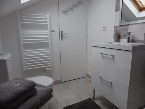 凡尔赛Les Tournelles的白色的浴室设有卫生间和水槽。