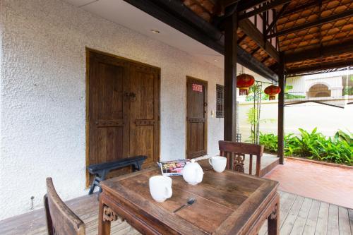 华欣BTC Hua Hin Home managed by BTC Boutique Resort的天井上的木桌和椅子