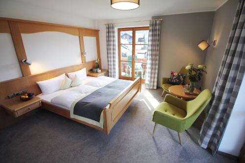 奥伯斯特多夫Gästehaus Gaymann的一间卧室配有一张床和一把绿色椅子