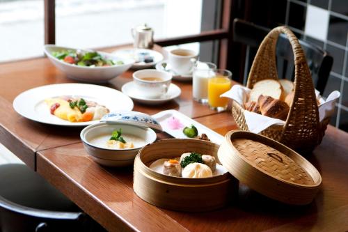 横滨Rose Hotel Yokohama, The Distinctive Collection By WORLDHOTELS的一张木桌,上面放着食物盘