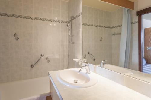 普拉茲德里斯Résidence Pierre & Vacances Les Mouflons I et II的白色的浴室设有水槽和浴缸。