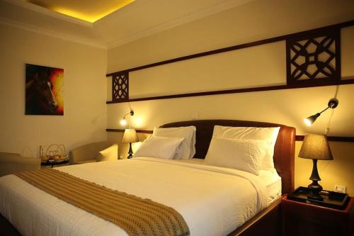 亚的斯亚贝巴埃塞俄比亚塞莱斯特酒店的一间卧室配有一张带两盏灯的大型白色床。