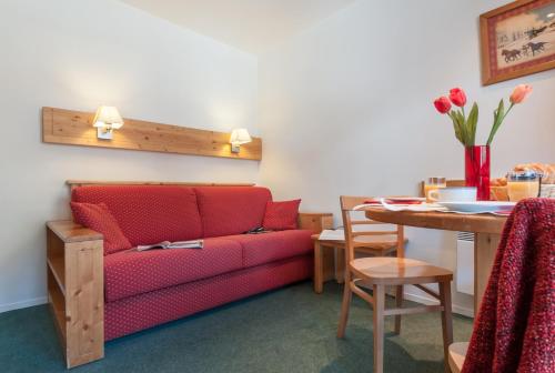 美贝尔Résidence Pierre & Vacances Le Peillon的客厅配有红色的沙发和桌子