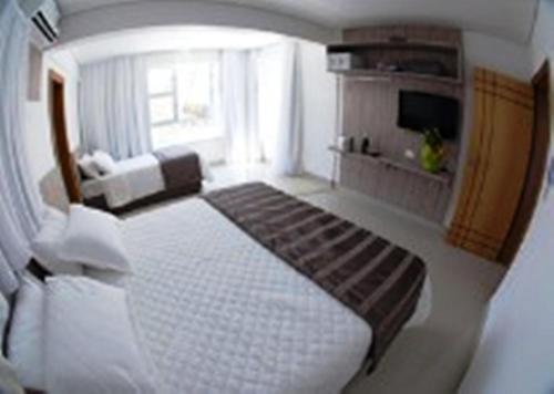 贝洛奥里藏特科尼克肖潘普利亚酒店的一间卧室设有一张床和一间客厅。