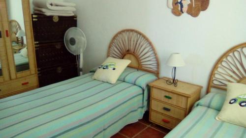 阿瓜阿马加El Cerrillo的一间卧室配有两张床、一个梳妆台和镜子