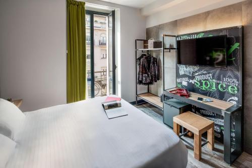 米兰米兰斯派斯酒店的一间卧室配有一张床,并在一间客房内配有电视。