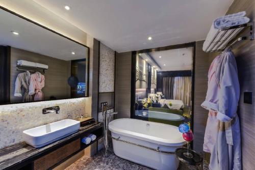 达曼Braira Al Dammam的一间带大镜子、浴缸和水槽的浴室