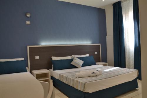 托雷拉皮罗Affittacamere Torre Lapillo的一间卧室设有两张带蓝色墙壁的床