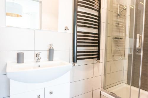 克罗斯诺Hostel 66的白色的浴室设有水槽和淋浴。