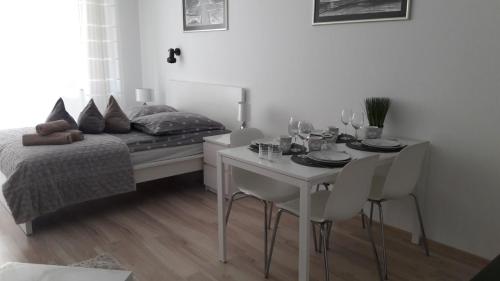 斯维诺乌伊希切Apartament 22 nad morzem的卧室配有一张床和一张桌子及椅子