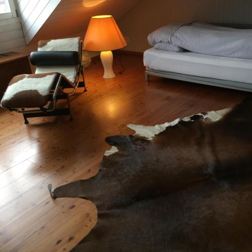 BottighofenRuheges Zimmer, 100 m zum See, Strandbad的卧室,卧室的地板很破,房间配有一张床和椅子