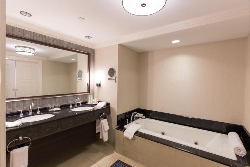 安卡斯维尔Mohegan Sun的浴室配有2个盥洗盆、浴缸和大镜子