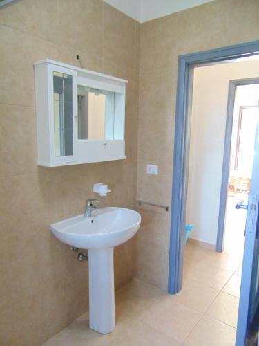 维耶斯泰Appartamento in villa con giardino Pizzomunno的浴室设有白色水槽和镜子