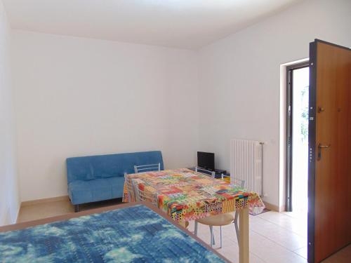 维耶斯泰Appartamento in villa con giardino Pizzomunno的客厅配有桌子和蓝色沙发