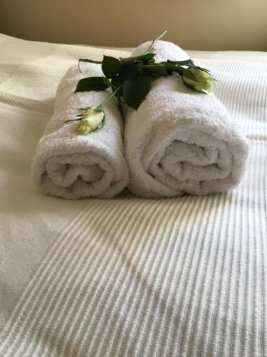 巴拉顿菲赖德Soós Apartman的床上的毛巾和鲜花