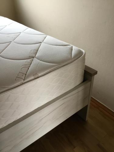 巴拉顿菲赖德Soós Apartman的一张床垫,放在一个房间里的床架上
