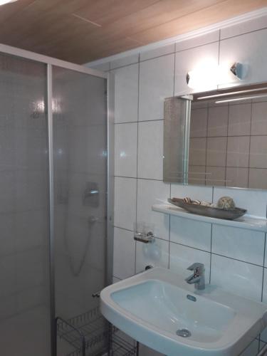 卡普尔Ferienhaus Nadine的带淋浴和盥洗盆的白色浴室