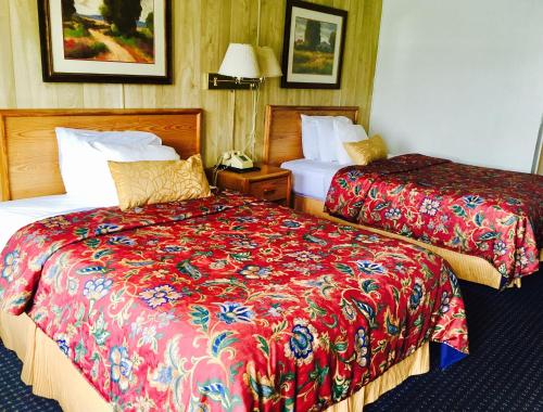 苏珊维尔河流酒店的酒店客房,配有两张带红色床单的床