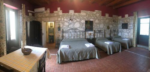 锡拉库扎Soleluna的一间卧室设有两张床和石墙