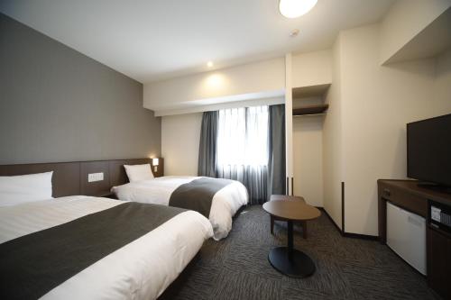 大分多美迎大分酒店的酒店客房设有两张床和一台平面电视。